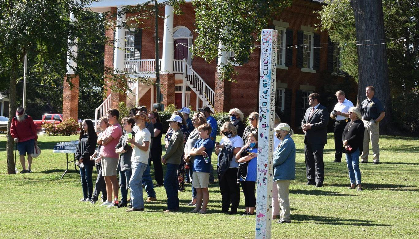 GATHERS AROUND PEACE POLE